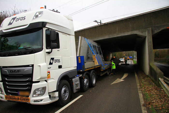 Vrachtwagenchauffeur rijdt met lading tegen spoorviaduct