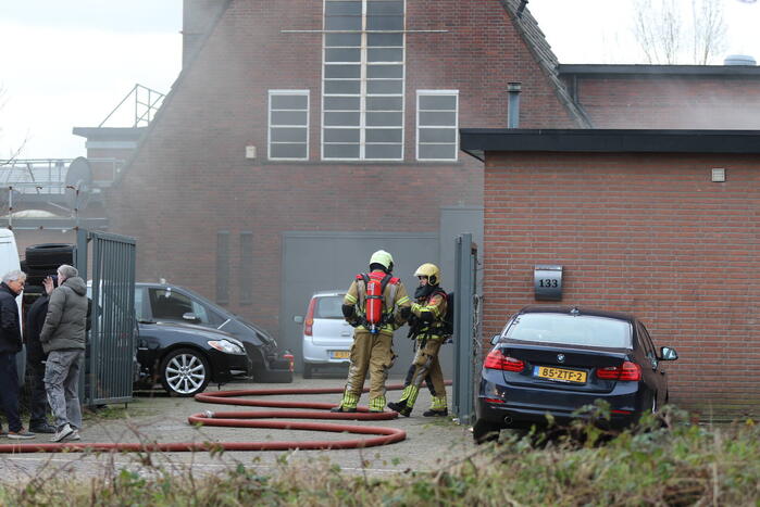Auto vliegt in spuitcabine in brand