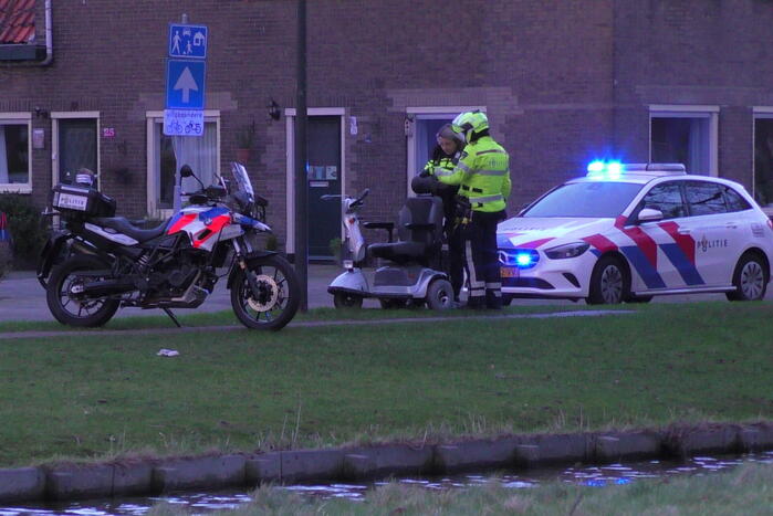 Persoon met scootmobiel te water