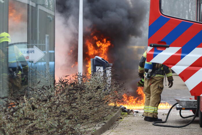 Auto vliegt in brand voor ingang carwash