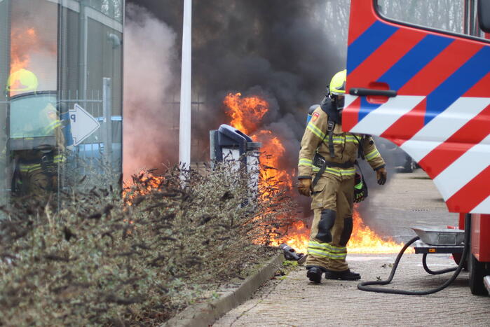 Auto vliegt in brand voor ingang carwash