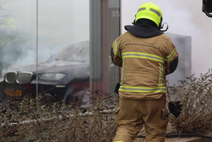 Auto vliegt in brand voor ingang carwash