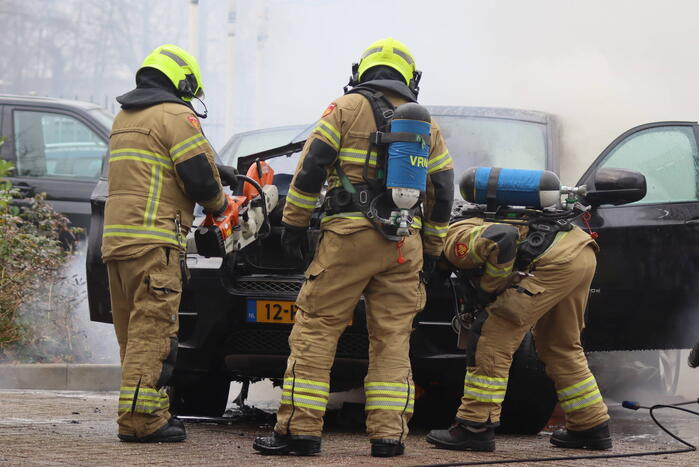 Auto vliegt in brand voor ingang carwash