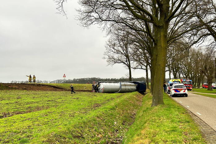 Vrachtwagen belandt op zijn kant naast de weg