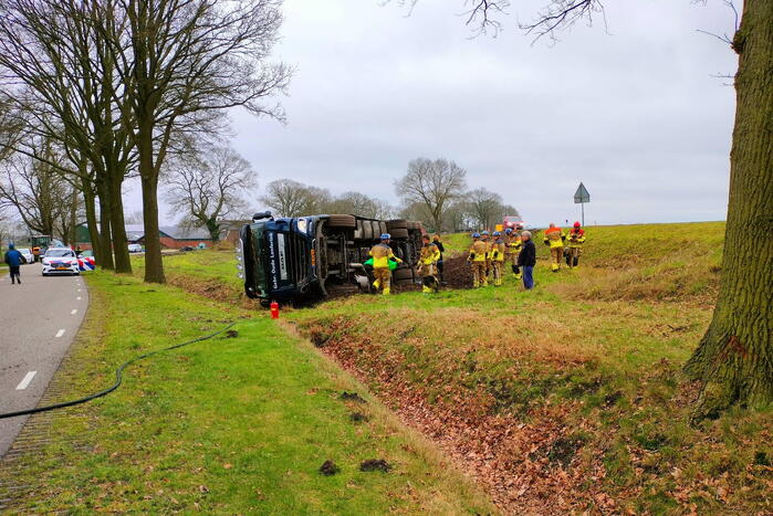 Vrachtwagen belandt op zijn kant naast de weg