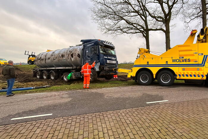 Vrachtwagen belandt op zijn kant naast de weg
