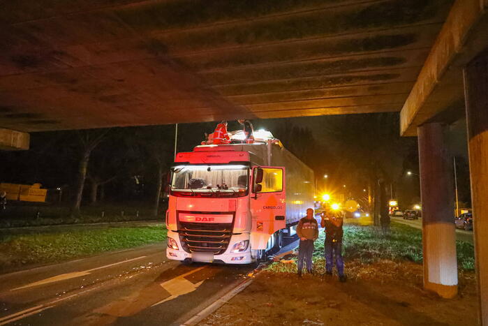 Te hoge vrachtwagen klem onder viaduct