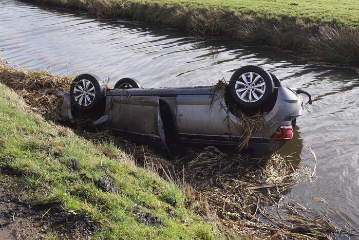 Auto raakt van de weg en belandt op de kop in sloot