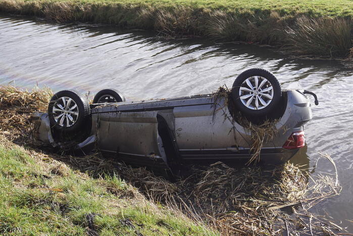 Auto raakt van de weg en belandt op de kop in sloot