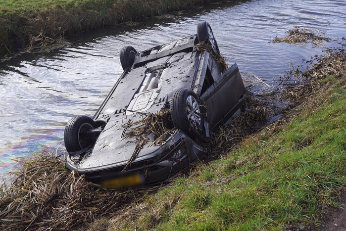 Auto raakt van de weg en belandt op de kop in sloot