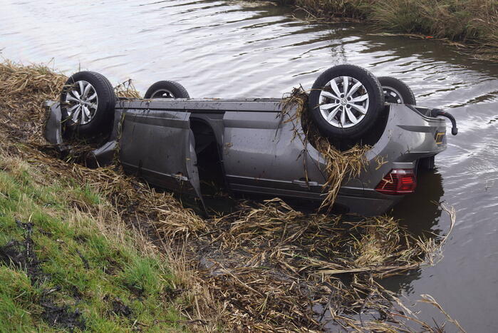 Auto raakt van de weg en belandt op de kop in sloot