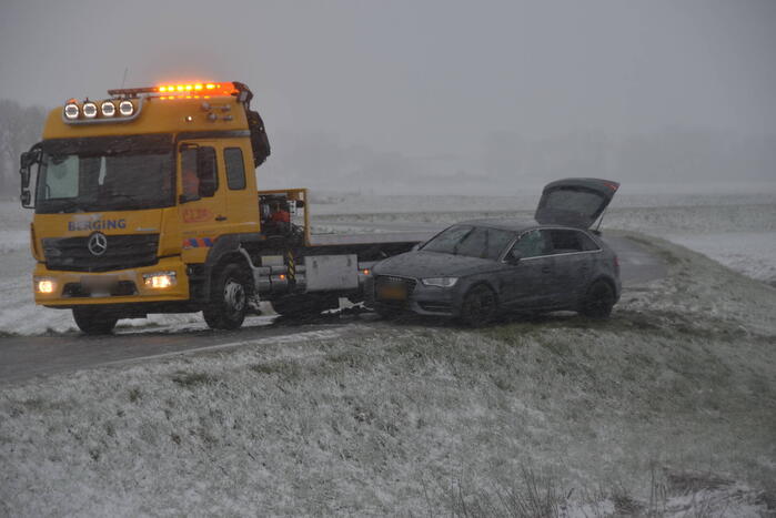 Twee personenauto's in berm van dijk belandt