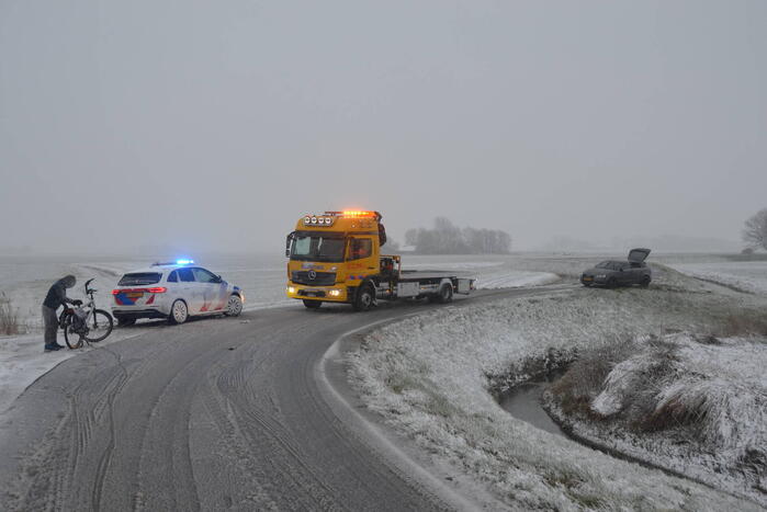 Twee personenauto's in berm van dijk belandt