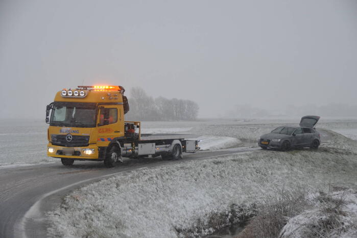 Twee personenauto's in berm van dijk belandt