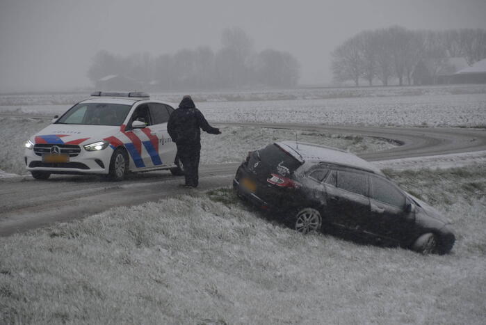 Twee personenauto's in berm van dijk belandt