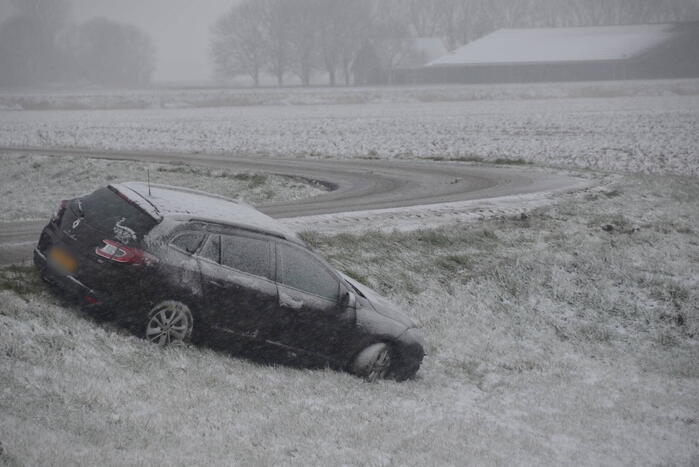 Twee personenauto's in berm van dijk belandt