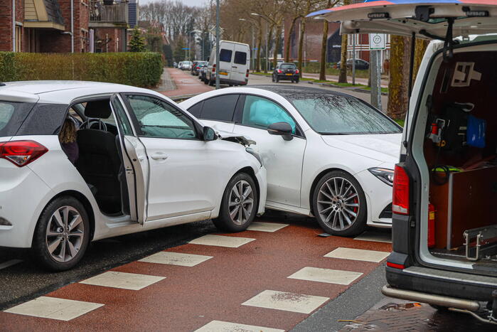 Twee personenauto's botsen op elkaar op kruising