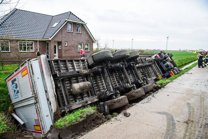 Chauffeur bekneld nadat vrachtwagen in sloot belandt