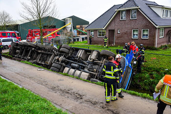 Chauffeur bekneld nadat vrachtwagen in sloot belandt