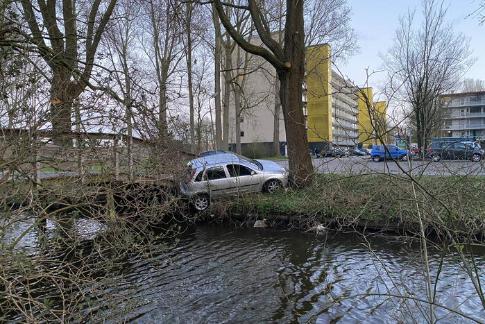 Auto vast tussen boom en brug, inzittenden slaan op de vlucht