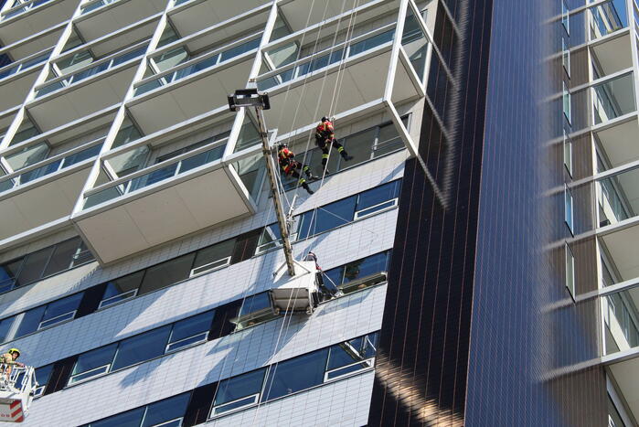 Glazenwasser gered uit vastzittend bakje aan gevel