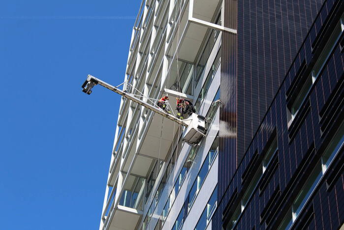 Glazenwasser gered uit vastzittend bakje aan gevel