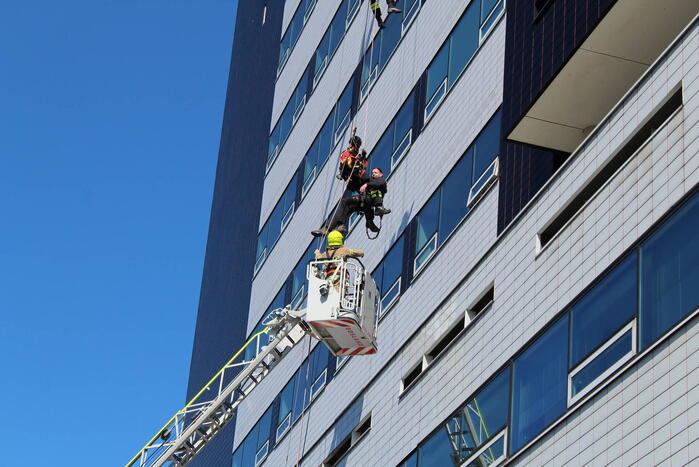 Glazenwasser gered uit vastzittend bakje aan gevel