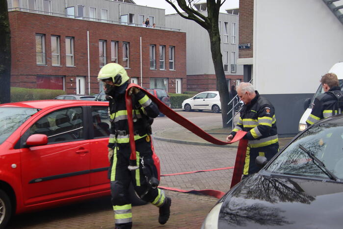 Brandweer blust brand in papiercontainer