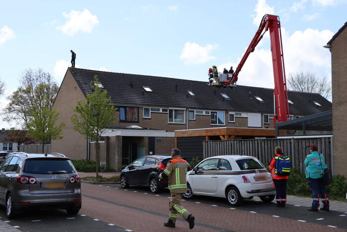 Twee personen op dak van woning