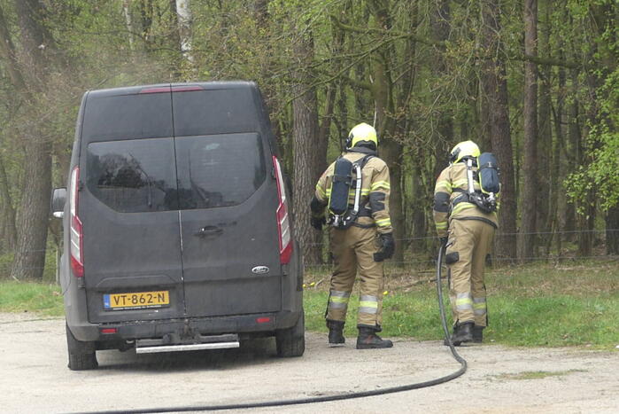 Bestelbus met afval in brand gestoken op parkeerplaats bij bos, twee aanhoudingen