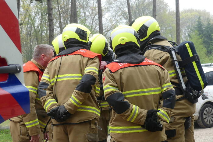 Bestelbus met afval in brand gestoken op parkeerplaats bij bos, twee aanhoudingen