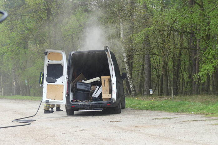 Bestelbus met afval in brand gestoken op parkeerplaats bij bos, twee aanhoudingen