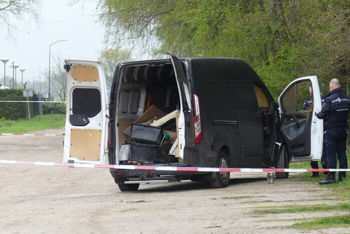 Bestelbus met afval in brand gestoken op parkeerplaats bij bos, twee aanhoudingen