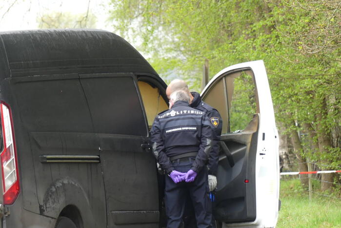 Bestelbus met afval in brand gestoken op parkeerplaats bij bos, twee aanhoudingen