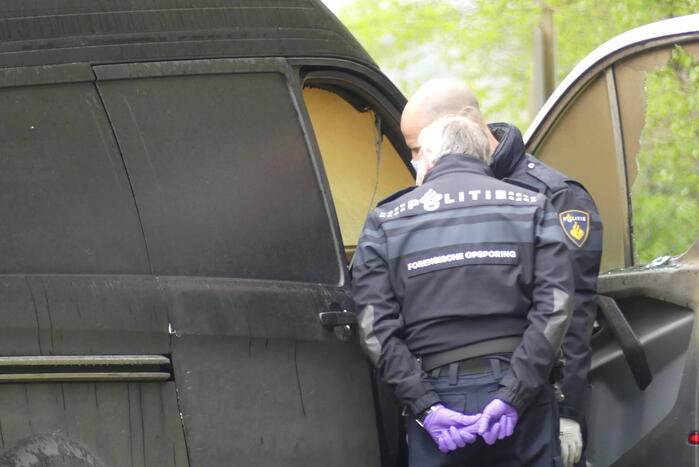 Bestelbus met afval in brand gestoken op parkeerplaats bij bos, twee aanhoudingen