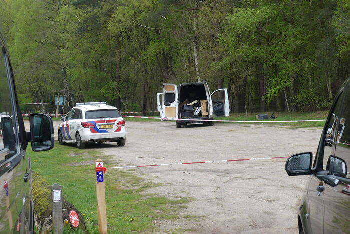 Bestelbus met afval in brand gestoken op parkeerplaats bij bos, twee aanhoudingen