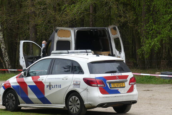 Bestelbus met afval in brand gestoken op parkeerplaats bij bos, twee aanhoudingen