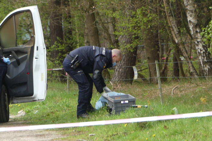 Bestelbus met afval in brand gestoken op parkeerplaats bij bos, twee aanhoudingen
