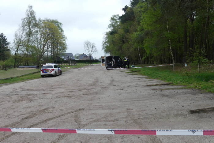 Bestelbus met afval in brand gestoken op parkeerplaats bij bos, twee aanhoudingen