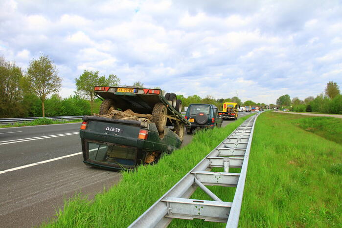 Jeep op aanhanger belandt op de kop