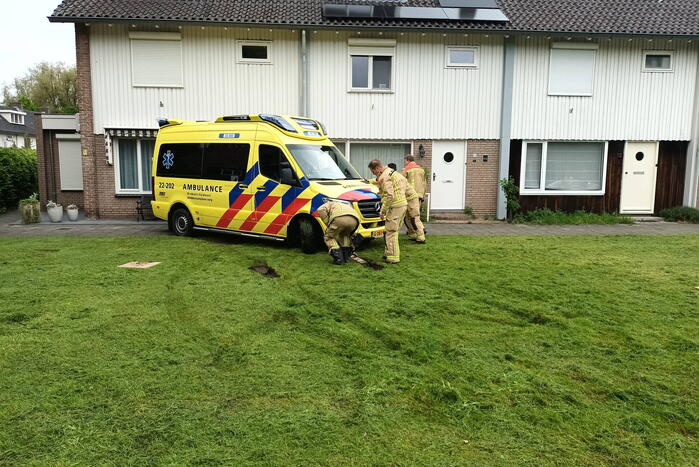 Ambulance rijdt zich vast op grasveld voor woning