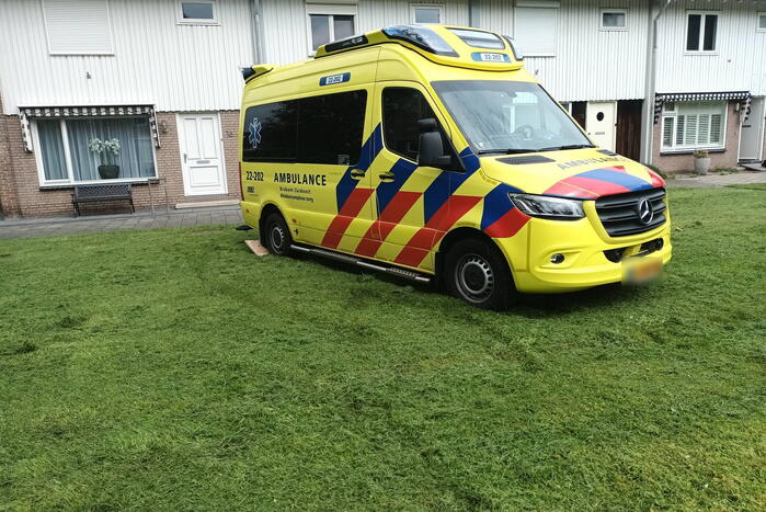Ambulance rijdt zich vast op grasveld voor woning