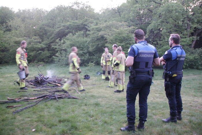 Brandweer blust kampvuur in bos