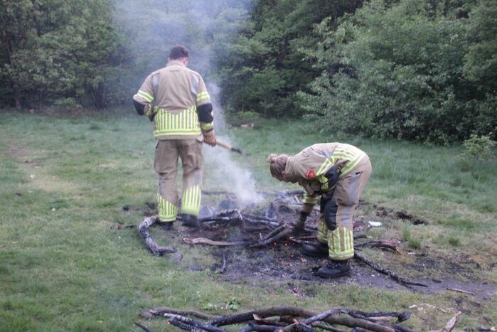 Brandweer blust kampvuur in bos