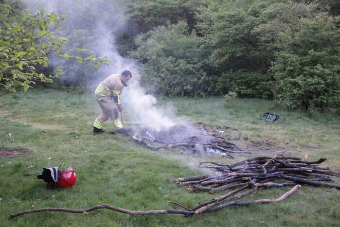 Brandweer blust kampvuur in bos