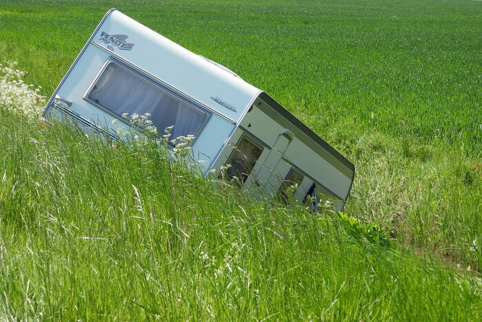Caravan raakt los van auto en belandt in sloot