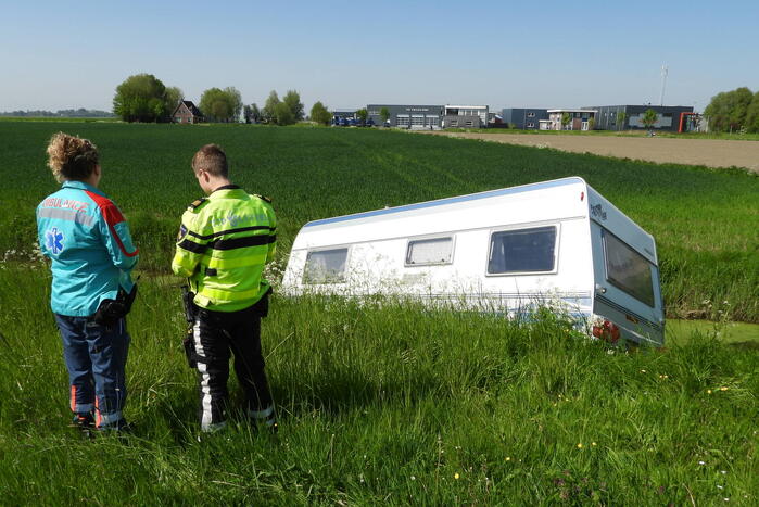 Caravan raakt los van auto en belandt in sloot