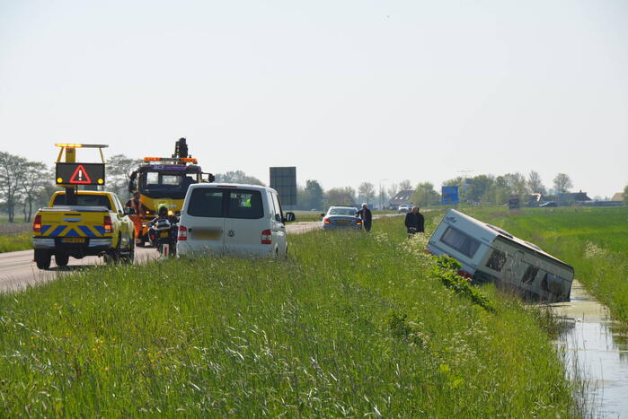 Caravan raakt los van auto en belandt in sloot