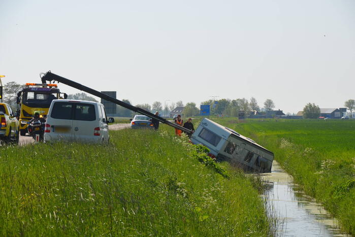 Caravan raakt los van auto en belandt in sloot