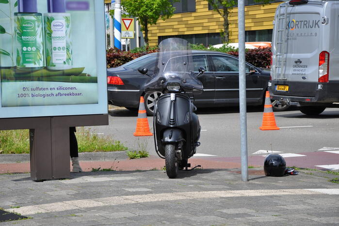 Verkeersongeval op rotonde, scooterrijder gewond